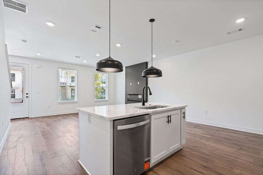 Kitchen island featuring a white countertop, undermount sink, and matte black faucet Kitchen island featuring a white countertop, undermount sink, and matte black faucet