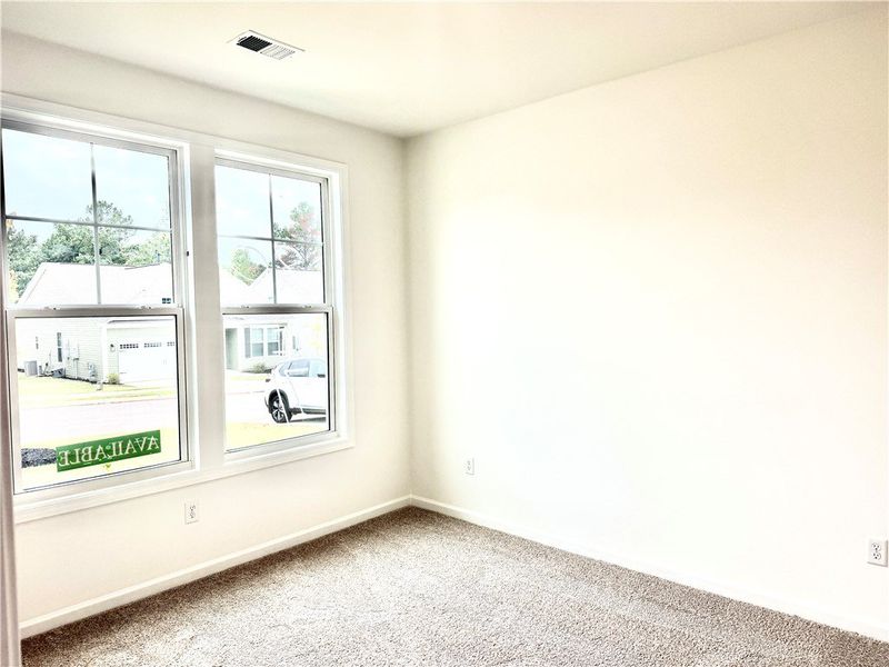 Natural light pours through large windows onto sof