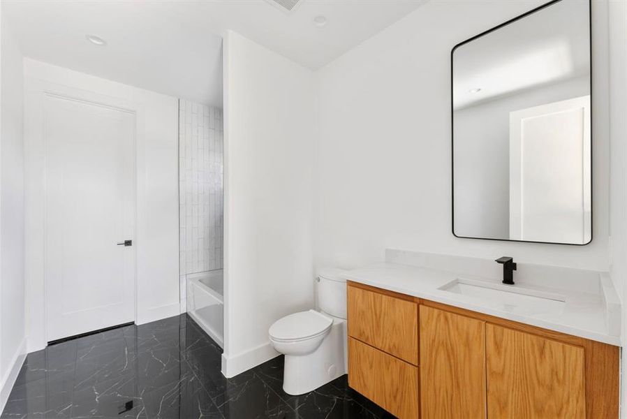 Full bathroom with vanity, shower / tub combination, dark marble finish flooring, and recessed lighting Full bathroom with vanity, shower / tub combination, dark marble finish flooring, and recessed lighting