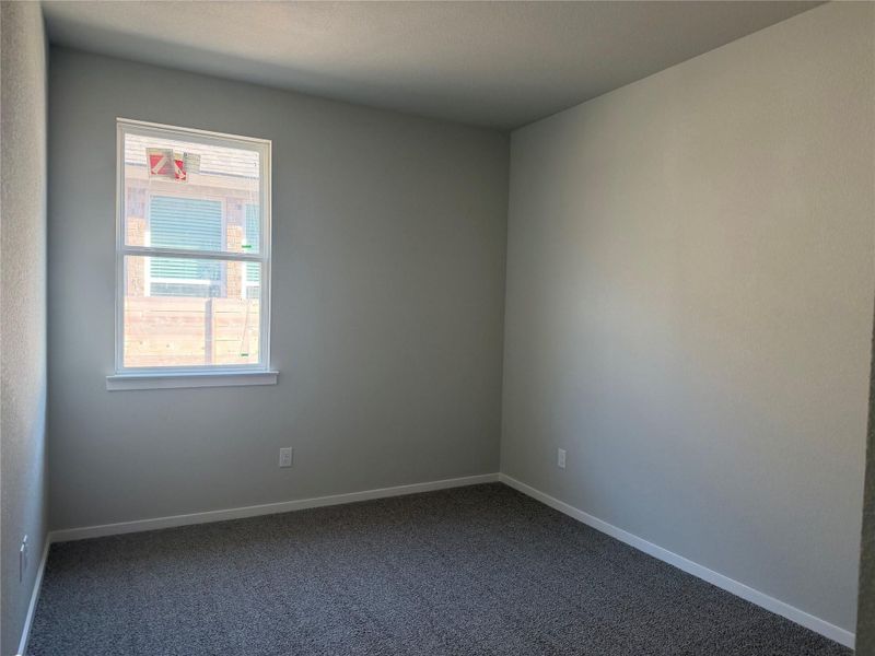 Soft wall tones complement plush carpeting and a single window in this versatile space.