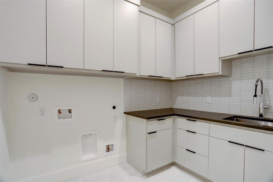 The main utility room is located between the second floor bedrooms and offers plenty of cabinet and counter space with a sink.