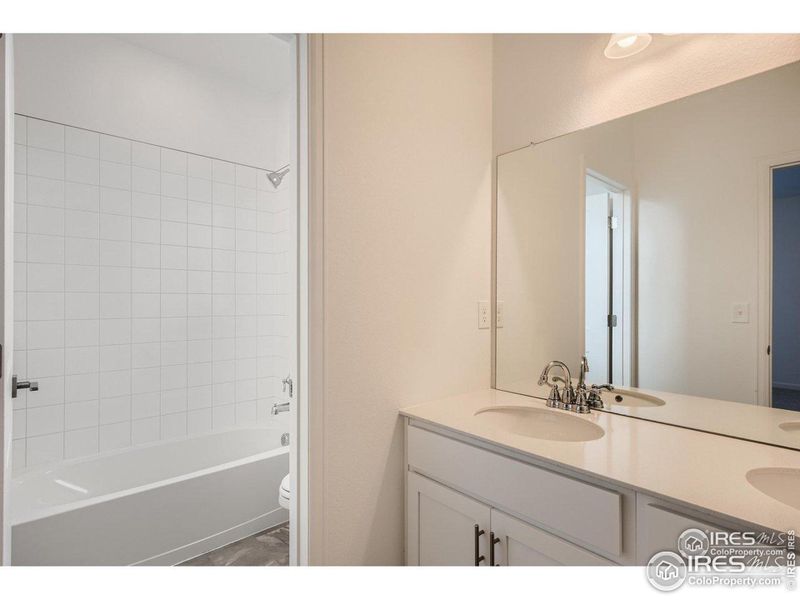 Upstairs bath with double vanity and quartz counters.