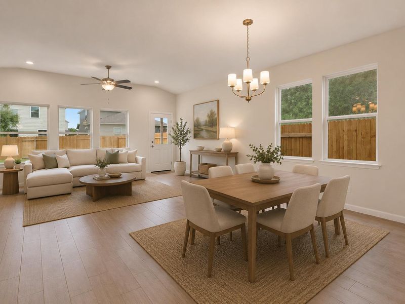 An inviting open-concept area combines living and dining spaces, illuminated by natural light through large windows and a classic chandelier.