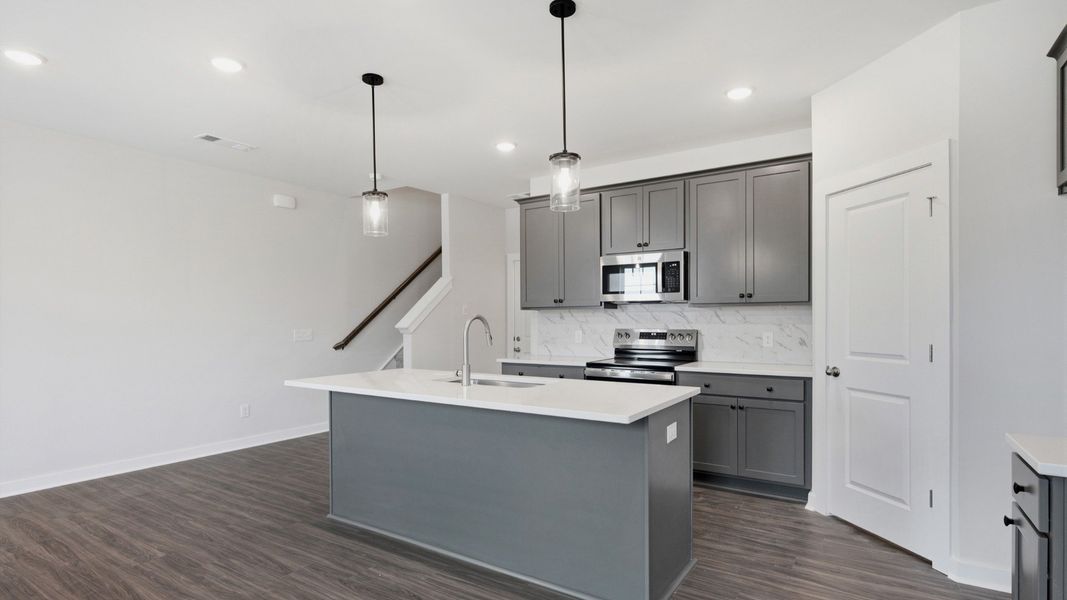 Kitchen with island and pantry door next to entryway