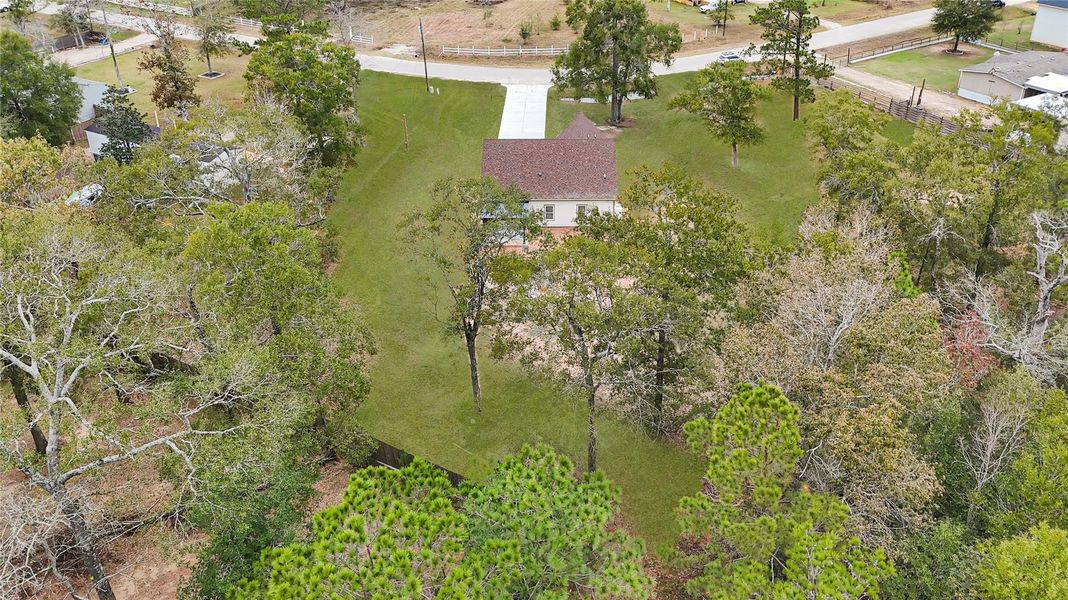 This aerial photo shows a charming home nestled among mature trees, with a spacious front yard and a long driveway leading to the house. The property offers ample greenery and privacy, ideal for those seeking a serene, natural setting. This aerial photo shows a charming home nestled among mature trees, with a spacious front yard and a long driveway leading to the house. The property offers ample greenery and privacy, ideal for those seeking a serene, natural setting.