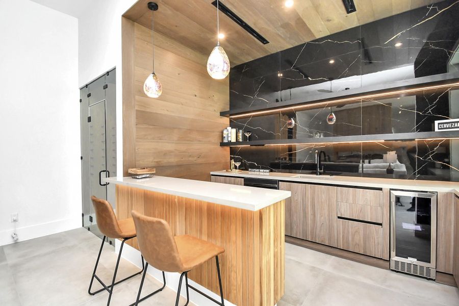 Wetbar with island features wine fridge, dishwasher, and sink perfect for entertaining. Wetbar with island features wine fridge, dishwasher, and sink perfect for entertaining.