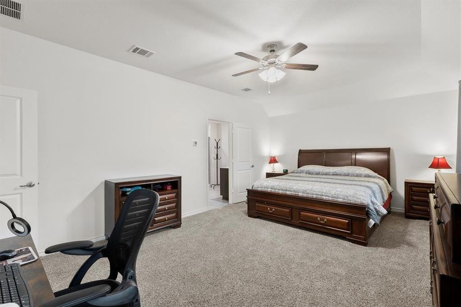 Bedroom with light colored carpet, a desk, ceiling fan, and lofted ceiling