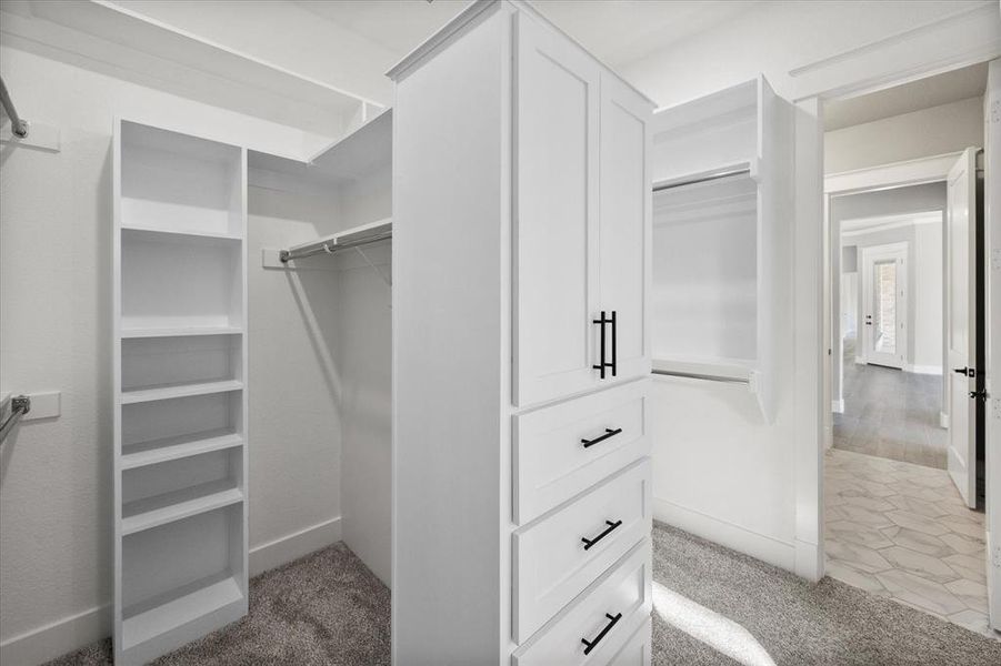 Primary closet connecting en-suite bath to laundry room