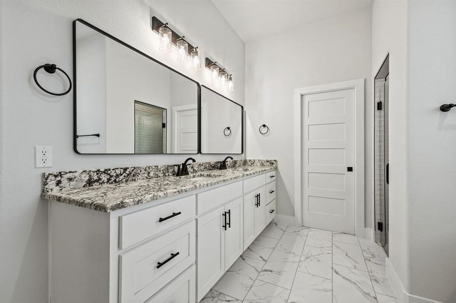 Full bathroom featuring marble finish floor, double vanity, a sink, and baseboards