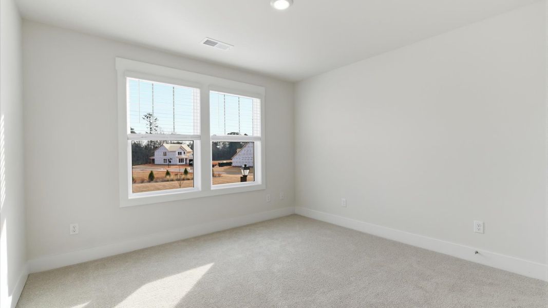Accomplished design shines in this carpeted bedroom with a functional walk-in closet