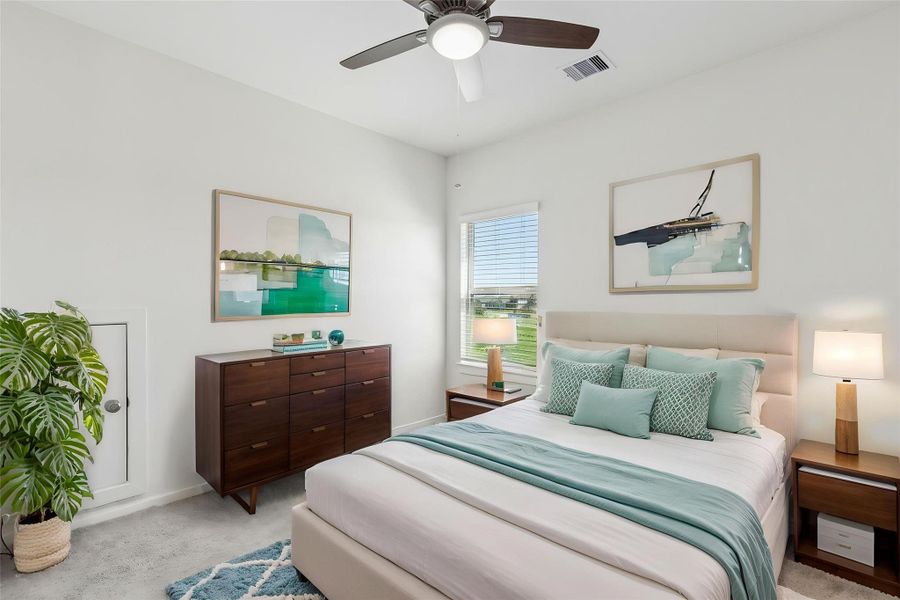 This bright secondary bedroom features a ceiling fan, neutral carpeting, and energy-efficient Low-E windows. The functional layout and large closet create a peaceful guest retreat. This space has been virtually staged to showcase its potential.