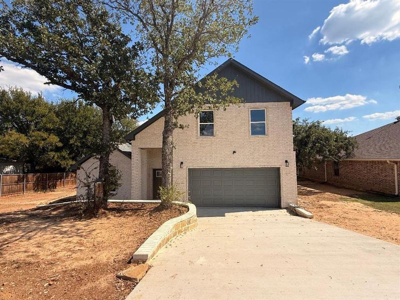 Traditional-style house featuring brick siding, concrete driveway, and a garage Traditional-style house featuring brick siding, concrete driveway, and a garage
