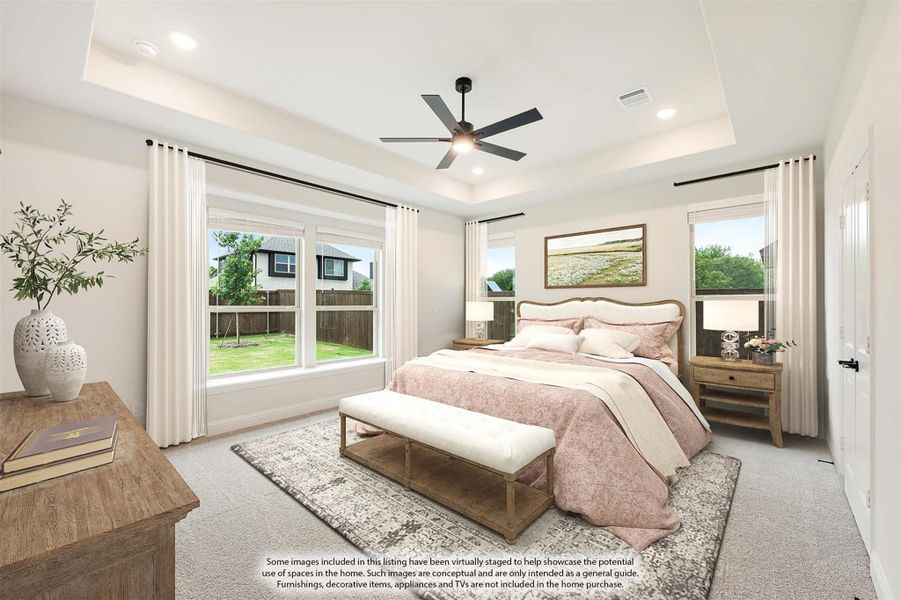 Master bedroom with tray ceiling, ceiling fan, carpet flooring, and large windows with backyard views Master bedroom with tray ceiling, ceiling fan, carpet flooring, and large windows with backyard views