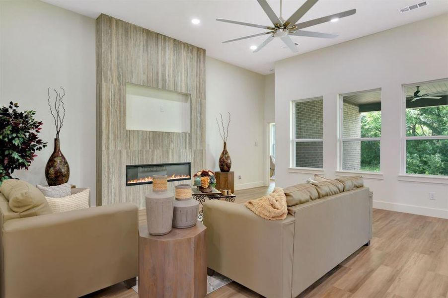 Living area featuring a floor-to-ceiling accent wall with a linear fireplace and a recessed media niche Living area featuring a floor-to-ceiling accent wall with a linear fireplace and a recessed media niche