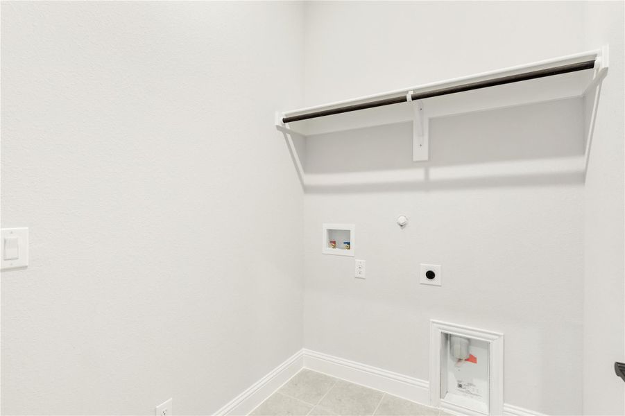 Laundry room with wall-mounted shelf, hanging rod, washer hookups, and dryer vent connection