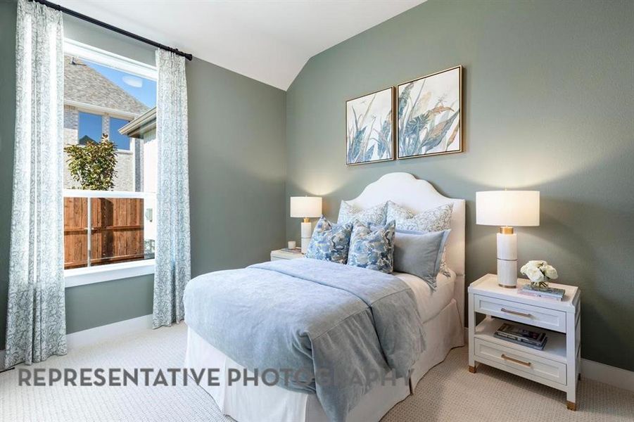 Carpeted bedroom with baseboards and lofted ceiling