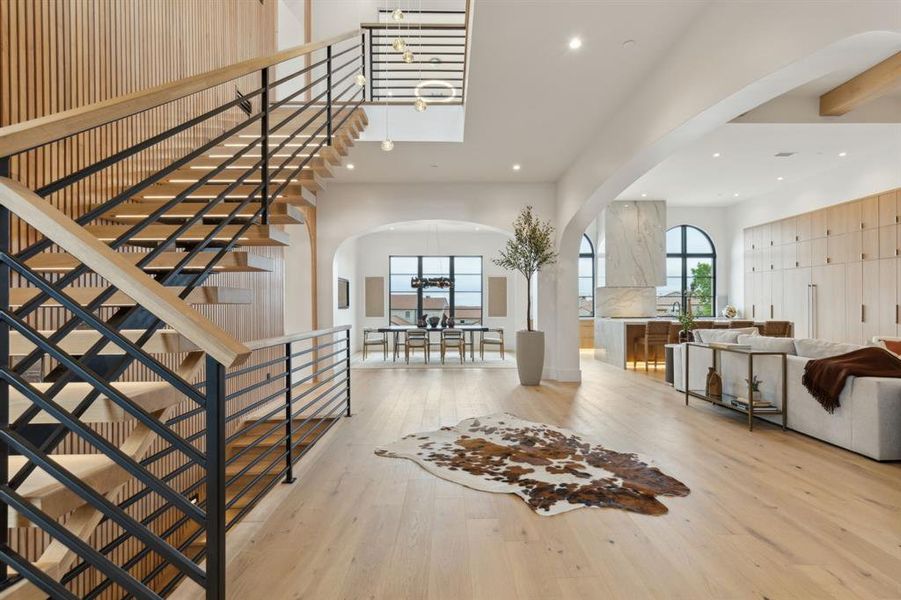 Foyer featuring floating staircase, wall wood accents, designer lighting Foyer featuring floating staircase, wall wood accents, designer lighting