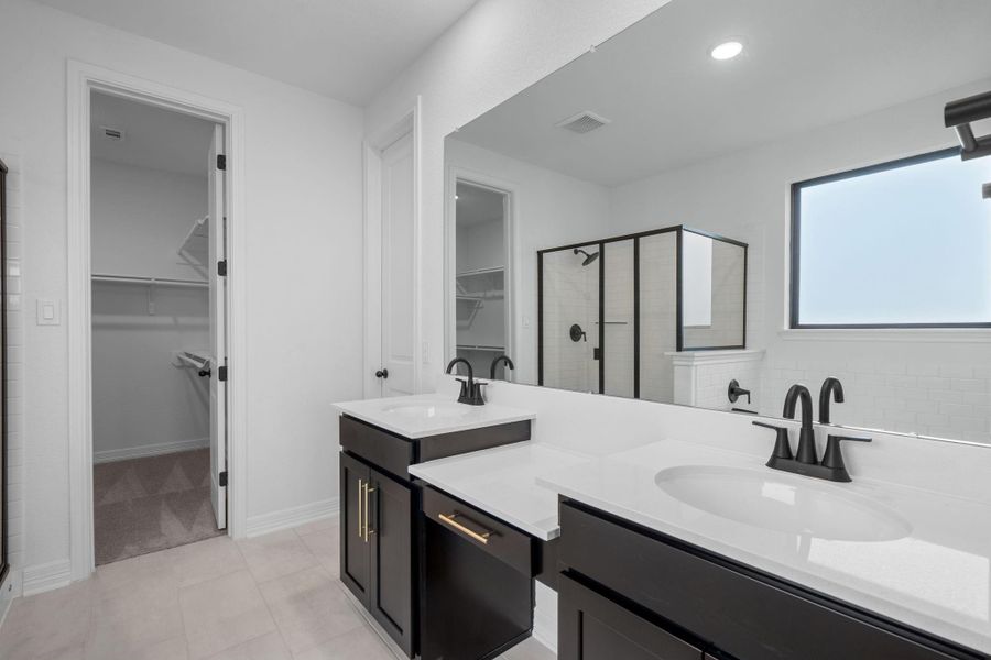 The en-suite bathroom offers a spa-like atmosphere with its elegant design, high end finishes, and tasteful lighting, creating a retreat within your own home.