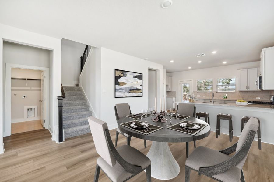 Virtually staged dining room and kitchen in the Medina floorplan at a Meritage Homes community.