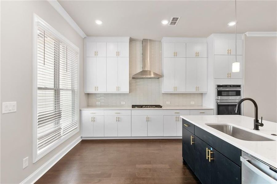 White stacked cabinets at the perimeter with a herringbone tile backsplash. Photos are not of the exact property but are similar, the home is currently under construction.