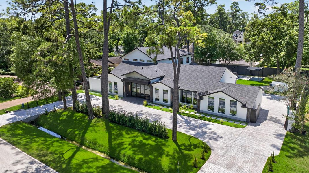 Aerial perspective captures the residence, expansive lawn and established tree canopy.