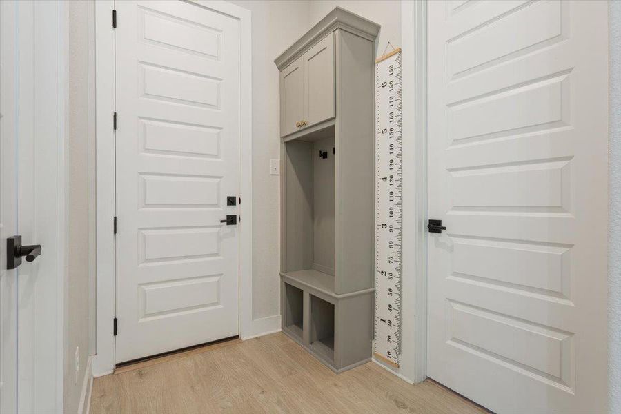 Mudroom featuring light wood finished floors and baseboards