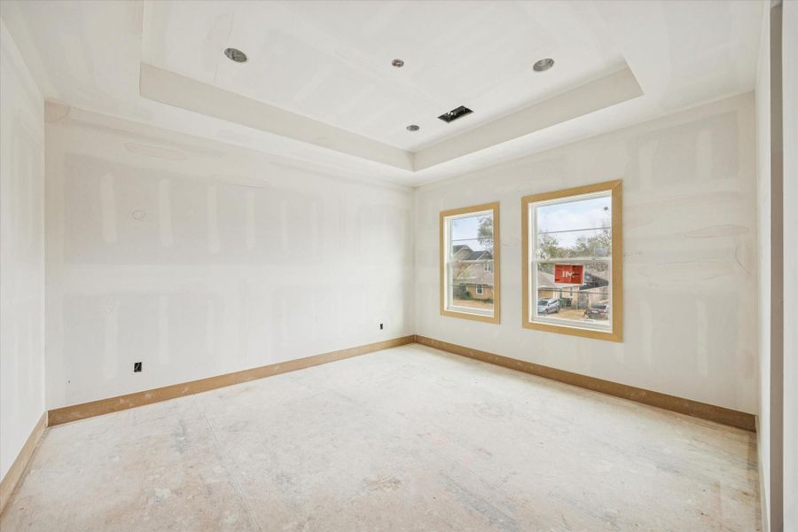 Inviting secondary bedroom with tray ceiling detail and dual windows for balanced natural light. Positioned upstairs with convenient access to en suite or Jack and Jill bath, offering comfort and privacy for family or guests.