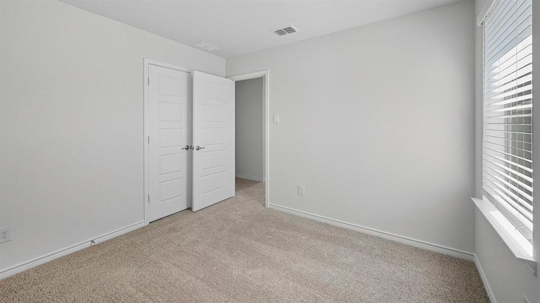 Unfurnished bedroom featuring multiple windows and carpet floors