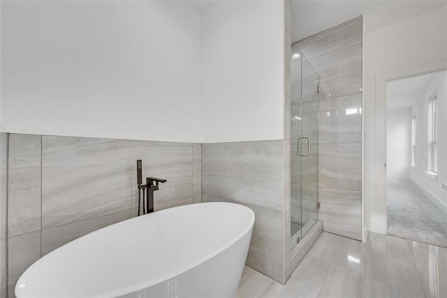 Full bath with a freestanding bath, a shower stall, and tile walls Full bath with a freestanding bath, a shower stall, and tile walls