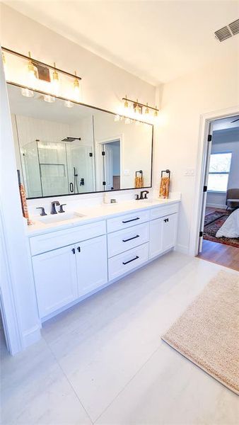 Bathroom featuring vanity, an enclosed shower, and wood-type flooring