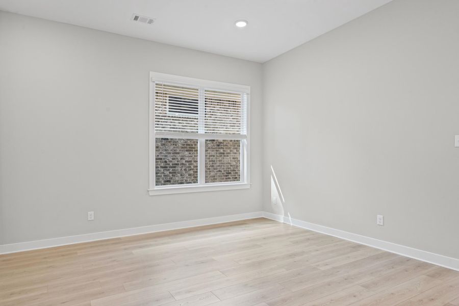 Empty room with light wood-type flooring and recessed lighting