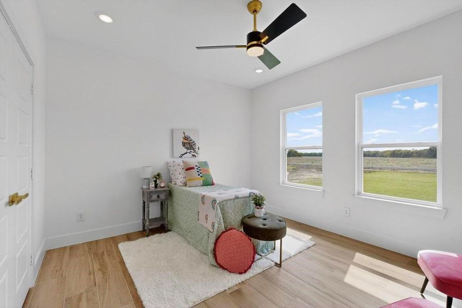Bedroom with light wood finished floors, ceiling fan, and recessed lighting