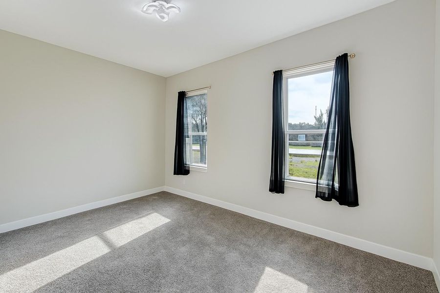 Carpeted spare room with baseboards Carpeted spare room with baseboards