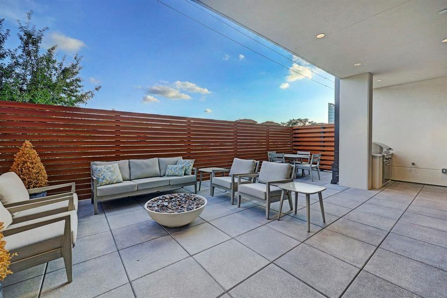 The common terrace includes privacy fencing surrounding the grilling and fire pit areas.