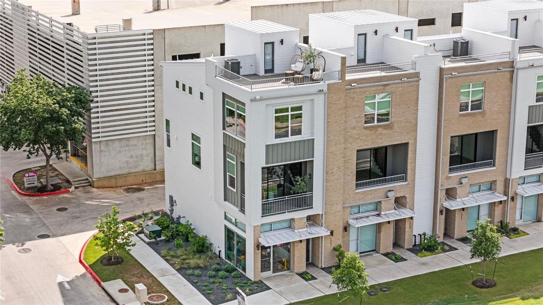 Contemporary townhome featuring a multi-level design with a flat roofline, white siding, and varied window placements