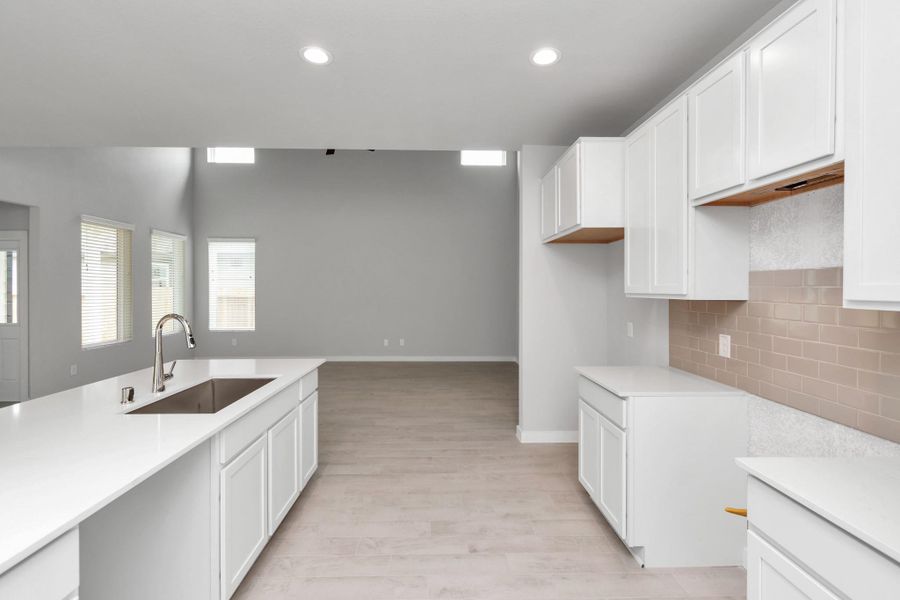 Discover another perspective of this stunning kitchen, generously appointed with an abundance of counter space. Sample photo of completed home with similar floor plan. Actual colors and selections may vary.
