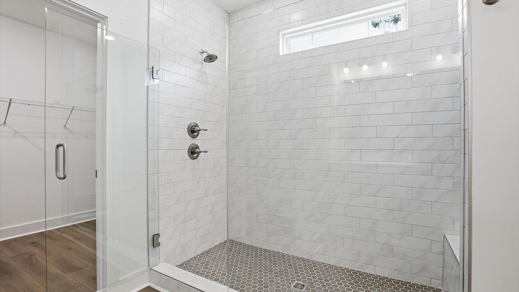 Superior en-suite primary bathroom with stylish dual vanity and tiled walk-in shower—crafted with high standards in mind