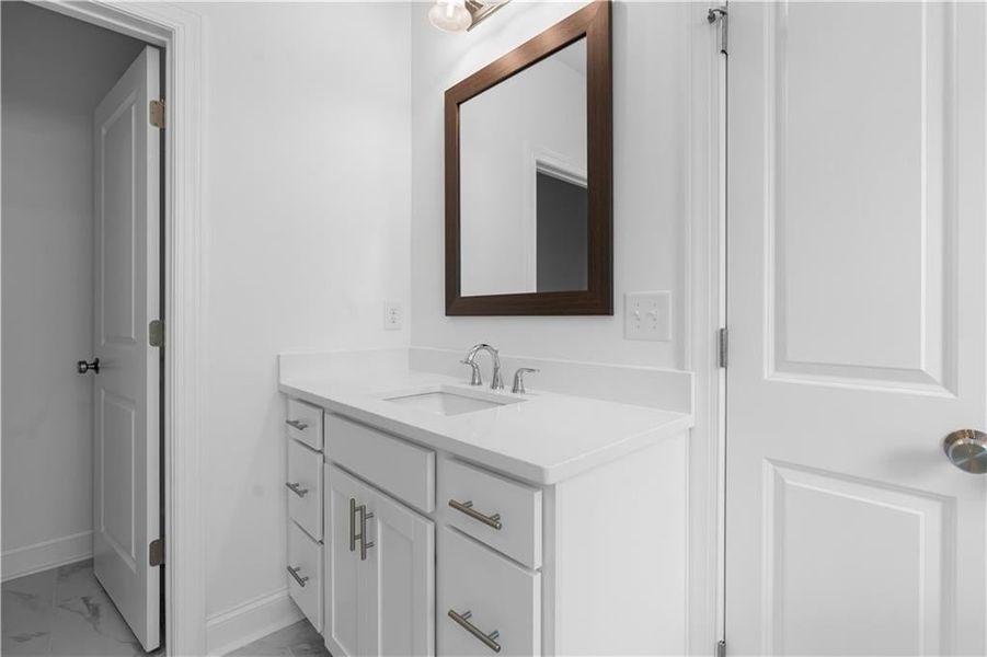 Primary bathroom with framed mirrors over vanities, tile flooring - Pictures represent a previously built home