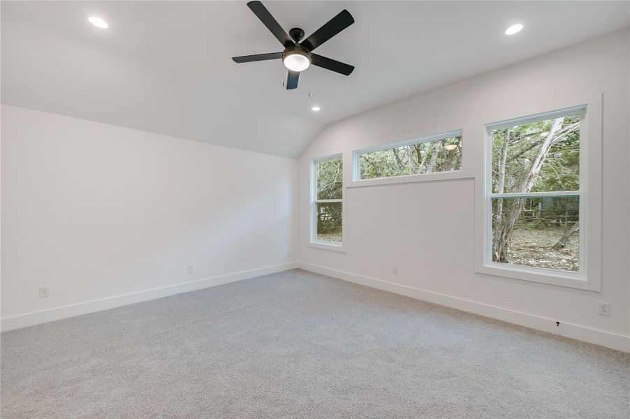 Unfurnished room with vaulted ceiling, recessed lighting, plenty of natural light, and baseboards