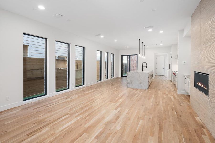 Unfurnished living room featuring a fireplace, light hardwood / wood-style floors, and sink