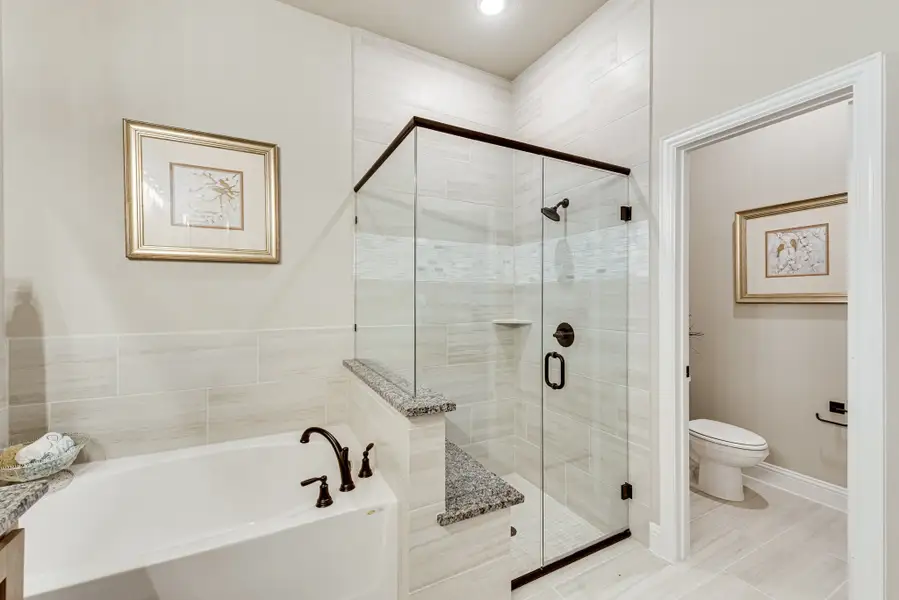 Master bathroom with soaking tub, glass walk-in shower, white tile walls, and separate water closet