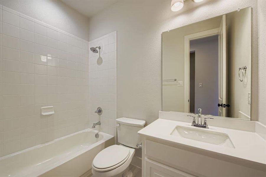 Bathroom with shower / tub combination, vanity, and a textured wall