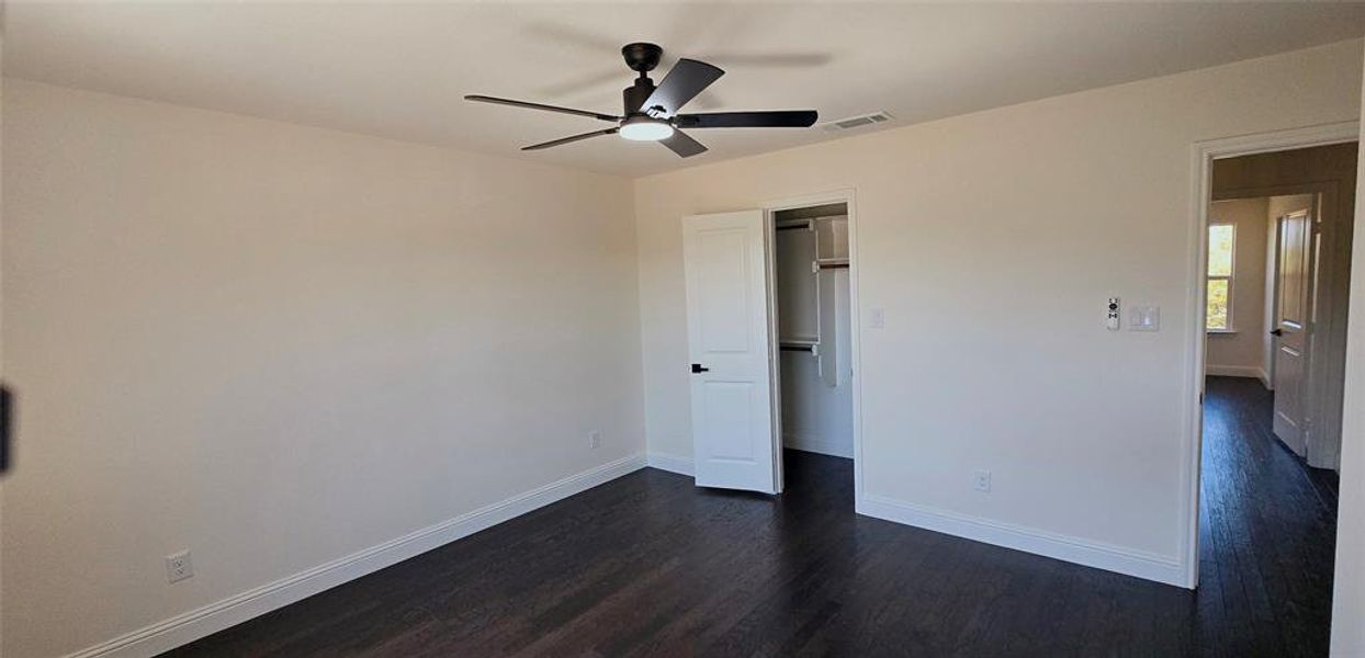 Unfurnished bedroom with dark wood-style flooring, a closet, and ceiling fan Unfurnished bedroom with dark wood-style flooring, a closet, and ceiling fan