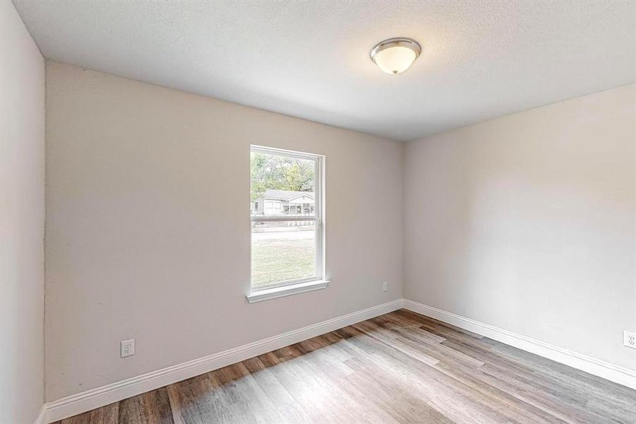 Empty room featuring a textured ceiling and light hardwood / wood-style floors