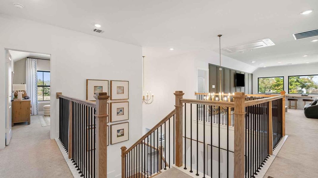 A grand staircase leading to the second floor with a luminating chandelier