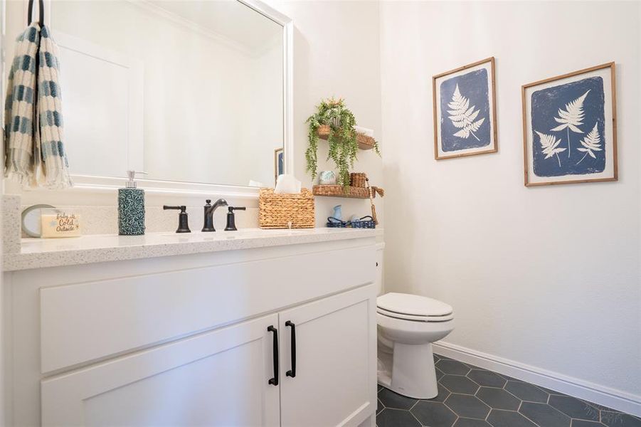 Half bath featuring vanity and toilet Half bath featuring vanity and toilet