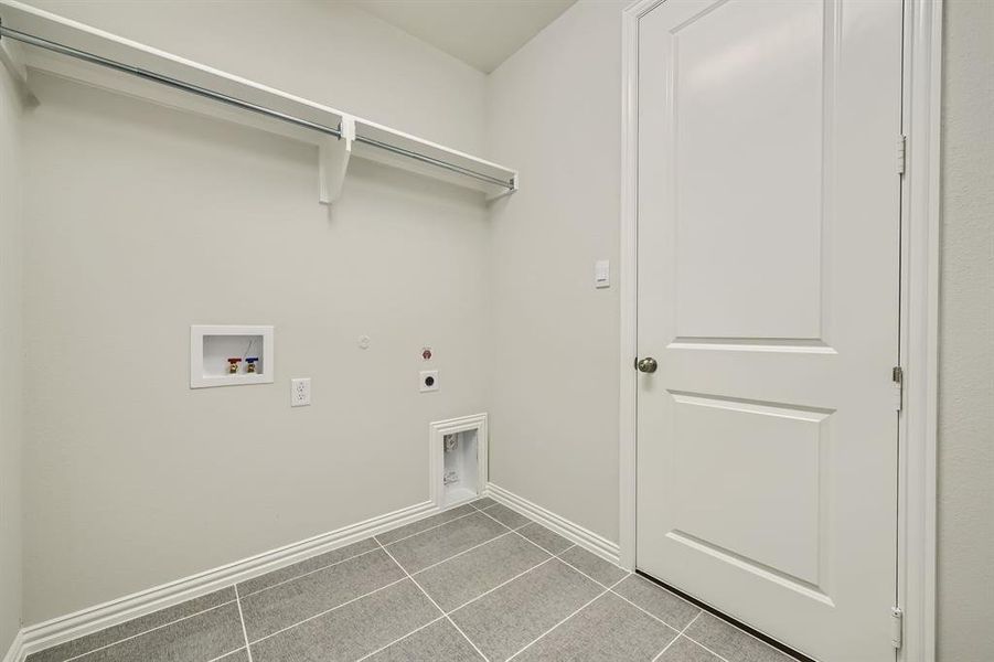 Laundry room with hookup for a gas dryer, electric dryer hookup, tile patterned flooring, and hookup for a washing machine