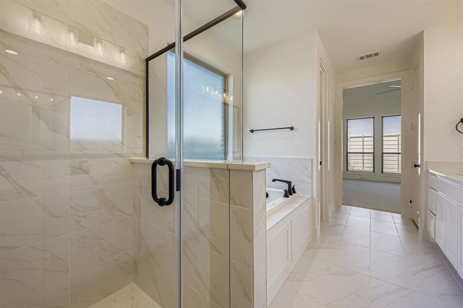 Full bathroom with a bath, a marble finish shower, vanity, and light marble finish floors Full bathroom with a bath, a marble finish shower, vanity, and light marble finish floors