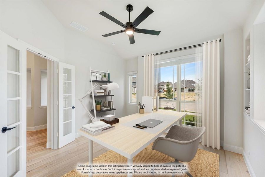 Home office with wood desk, ceiling fan, French doors, and large windows with natural light Home office with wood desk, ceiling fan, French doors, and large windows with natural light