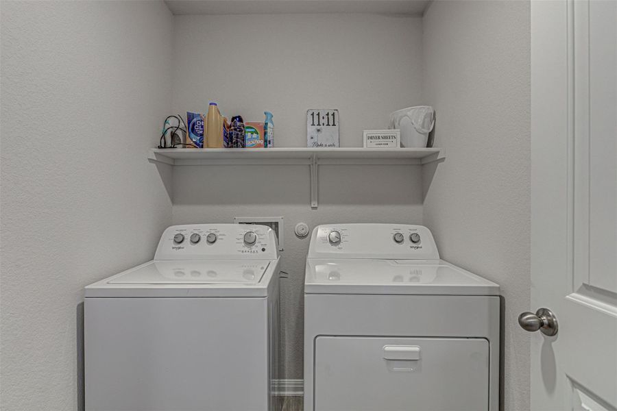 Laundry area featuring a textured wall and separate washer and dryer